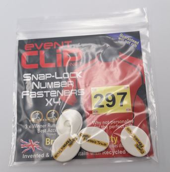 Plastic bag containing four circular Cystic Fibrosis Trust branded event clips used for attaching a running number to a running vest.